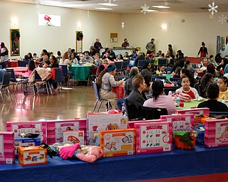 People eat before presents are distributed during Three Kings Day at OCCHA on Saturday afternoon. EMILY MATTHEWS | THE VINDICATOR