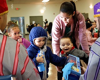 From left, Janeliz Garcia, 4, Abel Garcia, 3, and Abriel Garcia, 2, receive presents from the Three Kings with their mother Lizabeth Garcia, of Youngstown, during Three Kings Day at OCCHA on Saturday afternoon. EMILY MATTHEWS | THE VINDICATOR