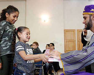 Abrianalis Saldana, 11, right, and Joselyn Bonilla, 6, both of Youngstown, receive presents from one of the Three Kings, Carlos Rosario, of Youngstown, during Three Kings Day at OCCHA on Saturday afternoon. EMILY MATTHEWS | THE VINDICATOR