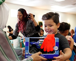 Noel Martinez, 4, of Youngstown, receives a present from one of the Three Kings, Jose Rene Vazquez, of Youngstown, during Three Kings Day at OCCHA on Saturday afternoon. EMILY MATTHEWS | THE VINDICATOR