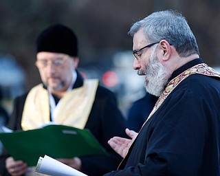 Father Tom Constantine, right, reads during the Blessing of the Waters Service at Lake Glacier in Mill Creek Park on Sunday afternoon. EMILY MATTHEWS | THE VINDICATOR