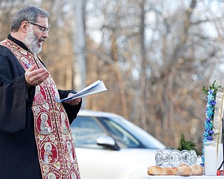 Father Tom Constantine says a prayer during the Blessing of the Waters Service at Lake Glacier in Mill Creek Park on Sunday afternoon. EMILY MATTHEWS | THE VINDICATOR