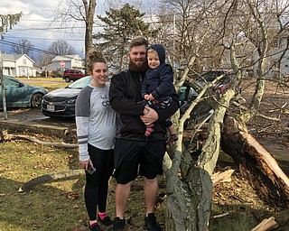 Michael Morris, his wife Sierra and their son Brantley, ,2, standby a large tree branch that fell in their side yard in Cortland this morning. One of the branches fell on their 2017 Malibu, damaging it.