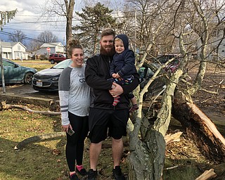 Michael Morris, his wife Sierra and their son Brantley, 2, stand by a large tree branch that fell in their side yard in Cortland this morning. One of the branches fell on their 2017 Malibu, damaging it.