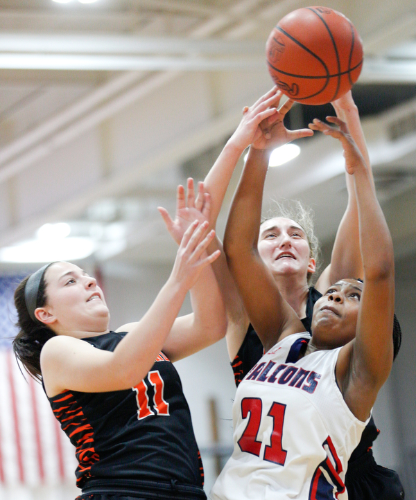 Fitch's Daria Williams, right, and Howland's Alyssa Pompelia, left, and Alex Ochman try to catch a rebound during the first half of their game at Fitch High School on Wednesday night. EMILY MATTHEWS | THE VINDICATOR