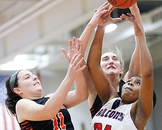 Fitch's Daria Williams, right, and Howland's Alyssa Pompelia, left, and Alex Ochman try to catch a rebound during the first half of their game at Fitch High School on Wednesday night. EMILY MATTHEWS | THE VINDICATOR