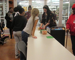 Neighbors | Jessica Harker.Community members snacked on fruit during the Michael Kusalaba library's first Kwanzaa celebration on Dec. 27.