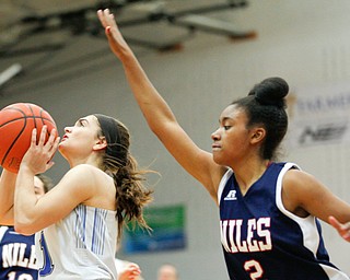 Poland's Brooke Bobbey looks towards the hoop while Niles' Aneziah Fryer tries to block her during their game at Poland on Thursday. EMILY MATTHEWS | THE VINDICATOR