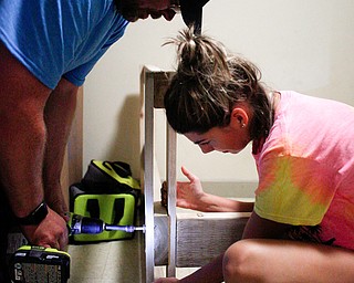 Jeff Watkins, of Cornersburg, left, and Meredith Eversole, 17, of Salem, drill the footboard to the bottom of a bunk bed they're building in a Campbell home with Sleep in Heavenly Peace on Saturday evening. Sleep in Heavenly Peace spent the day constructing the pieces of the bed and then took those pieces and built the bed in the home of a family who needed the bed. This was Sleep in Heavenly Peace's first build and delivery, but they said they have over 70 more requests for bunk beds in the area.