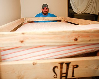 Travis Leonard, of Austintown, helps put a mattress down on a bunk bed that he helped build with Sleep in Heavenly Peace on Saturday evening. Sleep in Heavenly Peace spent the day constructing the pieces of the bed and then took those pieces and built the bed in the home of a family who needed the bed. This was Sleep in Heavenly Peace's first build and delivery, but they said they have over 70 more requests for bunk beds in the area.