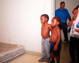 From left, Zion Johnson, 4, Xyayion Dotson, 3, and Miracle Morgan, 5, look at their new bunk bed provided and built by volunteers with Sleep in Heavenly Peace in their home in Campbell on Saturday night. Prior to receiving the bunk bed, the three children were sharing one mattress.