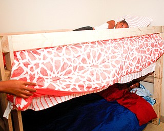 Miracle Morgan, 5, lays in the top bunk while her brother Zion Johnson lays in the bottom bunk of a bed provided and built by volunteers with Sleep in Heavenly Peace in their home in Campbell on Saturday night. Prior to receiving the bunk bed, Miracle, Zion, and their little brother Xyayion all shared one mattress.