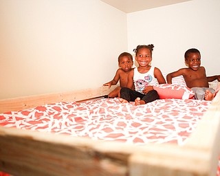 From left, Xyayion Dotson, 3, Miracle Morgan, 5, and Zion Johnson, 4, sit in the top bunk of their new bunk bed from Sleep in Heavenly Peace in their home in Campbell on Saturday night. Prior to receiving the bunk bed, the three children were sharing one mattress.