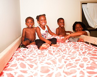 From left, Xyayion Dotson, 3, Miracle Morgan, 5, and Zion Johnson, 4, sit in the top bunk of their new bunk bed from Sleep in Heavenly Peace while their mother Jawan Murray stands next to them in their home in Campbell on Saturday night. Prior to receiving the bunk bed, the three children were sharing one mattress.