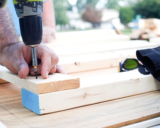 Dane "Mickey" Carder, of Canfield, drills screws into a piece of wood for a bunk bed he's helping to build with the group Sleep in Heavenly Peace for local children Saturday afternoon at the house of Travis Leonard, another group member, in Austintown.