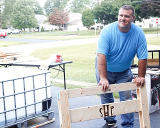 Dane "Mickey" Carder, of Canfield, stands with a headboard of a bunk bed he's helping to build with the group Sleep in Heavenly Peace for local children Saturday afternoon at the house of Travis Leonard, another group member, in Austintown.