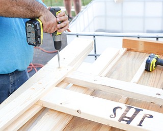 Dane "Mickey" Carder, of Canfield, drills holes into a piece of wood for a bunk bed he's helping to build with the group Sleep in Heavenly Peace for local children Saturday afternoon at the house of Travis Leonard, another group member, in Austintown.