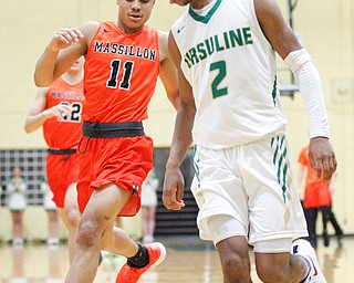 Ursuline's Daysean Harris and Massillon's Jaden Stock go after the ball during their game at Ursuline on Friday night. EMILY MATTHEWS | THE VINDICATOR