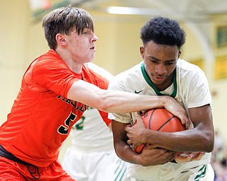 Ursuline's Jakylen Irving holds onto the ball while Massillon's  Anthony Pedro tries to grab it during their game at Ursuline on Friday night. EMILY MATTHEWS | THE VINDICATOR