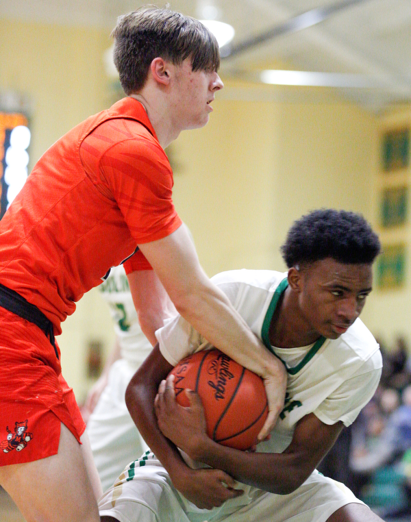 Ursuline's Jakylen Irving holds onto the ball while Massillon's  Anthony Pedro tries to grab it during their game at Ursuline on Friday night. EMILY MATTHEWS | THE VINDICATOR