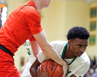 Ursuline's Jakylen Irving holds onto the ball while Massillon's  Anthony Pedro tries to grab it during their game at Ursuline on Friday night. EMILY MATTHEWS | THE VINDICATOR