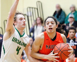 Massillon's Jayden Ballard drives the ball while Ursuline's Vince Armeni tries to block him during their game at Ursuline on Friday night. EMILY MATTHEWS | THE VINDICATOR