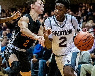 DIANNA OATRIDGE | THE VINDICATOR Boardman's Che Trevena (2) tries to drive the baseline against Howland's Gage Tomko (2) during the Spartans' 73-42 win in Boardman on Friday night.