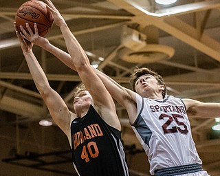 DIANNA OATRIDGE | THE VINDICATOR Boardman's Ethan Anderson (25) and Howland's Nathan Barrett (40) battle for a rebound during the Spartans' 73-42 win in Boardman on Friday night.