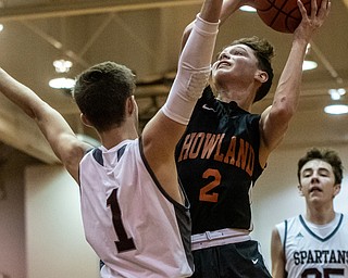 DIANNA OATRIDGE | THE VINDICATOR Howland's Gage Tomko (2) drives to the hoop against Boardman's Tommy Fryda (1) during the Spartans' 73-42 victory in Boardman on Friday night.