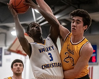 DIANNA OATRIDGE | THE VINDICATOR  Valley Christian's Damon Christian (3) tries to put up a shot against the defense of Mooney's Matt Brennan (20) during the Eagles' 58-56 victory in Youngstown on Tuesday. Mooney's Pete Haas (5) looks on.