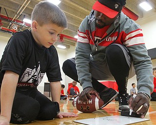 William D. Lewis The Vindicator Flag football player Ty Porter, 5, gets help diagraming a play from coach Elliott Giles.
