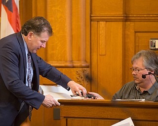 Witness Brian Martin, right, who worked at a gun store, confirms the gun Claudia Hoerig bought from the gun store and hands it back to Assistant Prosecutor Chris Becker during Hoerig's trial on Wednesday. EMILY MATTHEWS | THE VINDICATOR