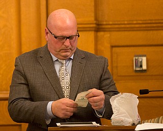 Witness Peter Pizzulo, former detective with the Trumbull County Sheriff's Office, holds a receipt from the gun shop that was found at the scene of the crime during Claudia Hoerig's trial on Wednesday. EMILY MATTHEWS | THE VINDICATOR