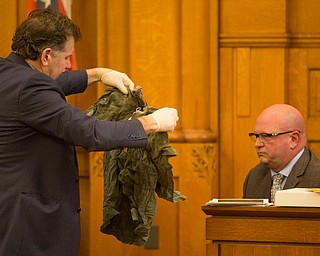 Assistant Prosecutor Chris Becker hands the shirt Karl Hoerig was wearing when he was killed to witness Peter Pizzulo, former detective with the Trumbull County Sheriff's Office, during Claudia Hoerig's trial on Wednesday. EMILY MATTHEWS | THE VINDICATOR