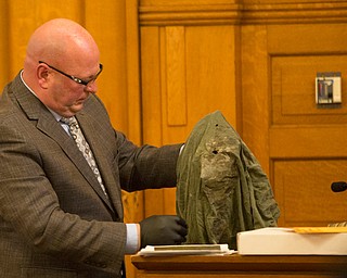 Witness Peter Pizzulo, former detective with the Trumbull County Sheriff's Office, holds up the shirt Karl Hoerig was wearing when he was killed during Claudia Hoerig's trial on Wednesday. EMILY MATTHEWS | THE VINDICATOR