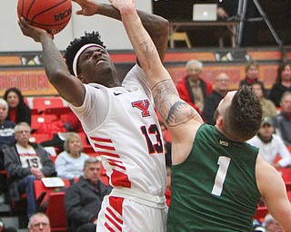 William D. Lewis The Vindicator  YSU's Donel CathcartIII (13) shoots past WSU's Bill Wampler(1)during 1-17-19 action at YSU.