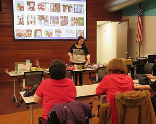 Neighbors | Jessica Harker.Librarian Hannah Matulek explained to community members the supplies the Michael Kusalaba library had available during the DIY Festive Mason Jars event on Dec. 17.