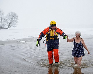 Minnie Wolfe, right, of Niles, participates in the Annual Polar Plunge with assistance from Chris Herlinger, with the Bazetta Fire Department, in Mosquito Lake in Cortland on Saturday. EMILY MATTHEWS | THE VINDICATOR