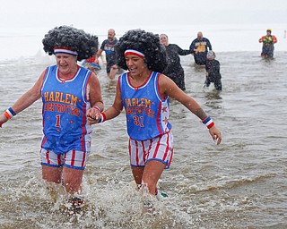 Jodi Omerzo, left, and Rena Ghirardi, both of Cortland, dressed up as the Harlem Globetrotters, participate in the Annual Polar Plunge in Mosquito Lake in Cortland on Saturday. EMILY MATTHEWS | THE VINDICATOR