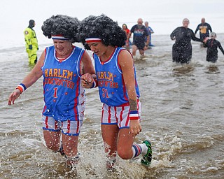 Jodi Omerzo, left, and Rena Ghirardi, both of Cortland, dressed up as the Harlem Globetrotters, participate in the Annual Polar Plunge in Mosquito Lake in Cortland on Saturday. EMILY MATTHEWS | THE VINDICATOR