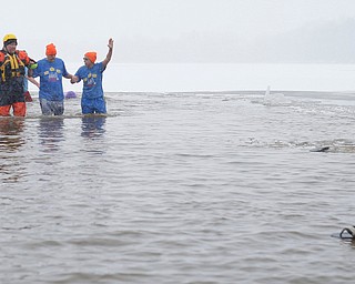 Craig Myers, center, a special olympian from Tampa, Florida, and his uncle Don Strock, right, of Champion, participate in the Annual Polar Plunge with assistance from Chris Herlinger, left, with the Bazetta Fire Department, in Mosquito Lake in Cortland on Saturday. EMILY MATTHEWS | THE VINDICATOR