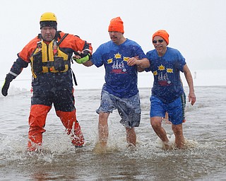 Craig Myers, center, a special olympian from Tampa, Florida, and his uncle Don Strock, right, of Champion, participate in the Annual Polar Plunge with assistance from Chris Herlinger, left, with the Bazetta Fire Department, in Mosquito Lake in Cortland on Saturday. EMILY MATTHEWS | THE VINDICATOR