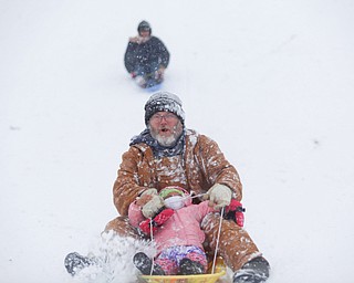 Jason Dean and Mila Cain, 1, of Cornersburg, sled ride at Wick Recreation Area on Saturday afternoon. EMILY MATTHEWS | THE VINDICATOR