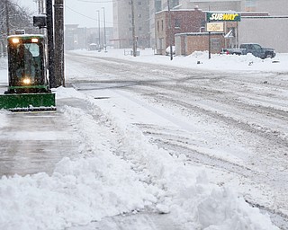 Michael Depizzo, of Liberty and with Depco Inc., plows a sidewalk on West Rayen Avenue on Saturday afternoon. EMILY MATTHEWS | THE VINDICATOR