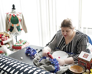 Doris Cochran works on "an ugly sweater," which she is planning to sell, Friday, Jan. 18, 2019, in her apartment in Arlington, Va., Cochran is a disabled mother of two young boys living in subsidized housing in Arlington, Va. She’s stockpiling canned foods to try to make sure her family won’t go hungry if her food stamps run out. She says she just doesn’t know “what’s going to happen” and that’s what scares her the most.