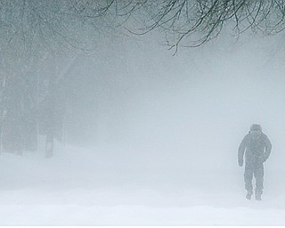 A man walks along a residential street during a snowstorm on Monday in Green Bay, Wis.  Temperatures in the Mahoning Valley will plummet Tuesday night below zero and be very low through Thursday with wind chills at times dropping to minus 30.
