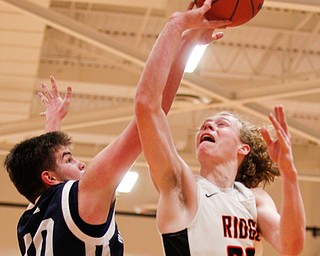 Mineral Ridge's Jordan Zupko tries to shoot the ball while McDonald's Jake Portolese reaches for it during their game at Mineral Ridge on Tuesday night. EMILY MATTHEWS | THE VINDICATOR