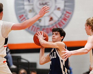 McDonald's Zack Rasile looks to pass the ball while Mineral Ridge's Koby Zupko, left, and Jordan Zupko, right, try to block him during their game at Mineral Ridge on Tuesday night. EMILY MATTHEWS | THE VINDICATOR