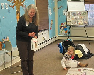 Neighbors | Jessica Harker.Naturalist Marilyn Williams explained to children gathered at the Tales for Tots event on Jan. 18 how to create an owl bird feeder.