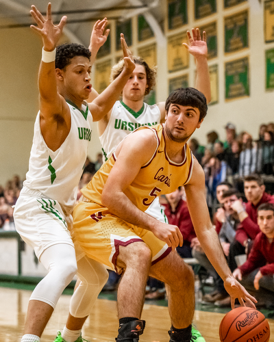 DIANNA OATRIDGE | THE VINDICATOR Cardinal Mooney's Pete Haas (5) drives the baseline under defensive pressure from Ursuline's Devan Keevey (left) and Vince Armeni (right) during Friday's game at Ursuline High School Gymnasium.